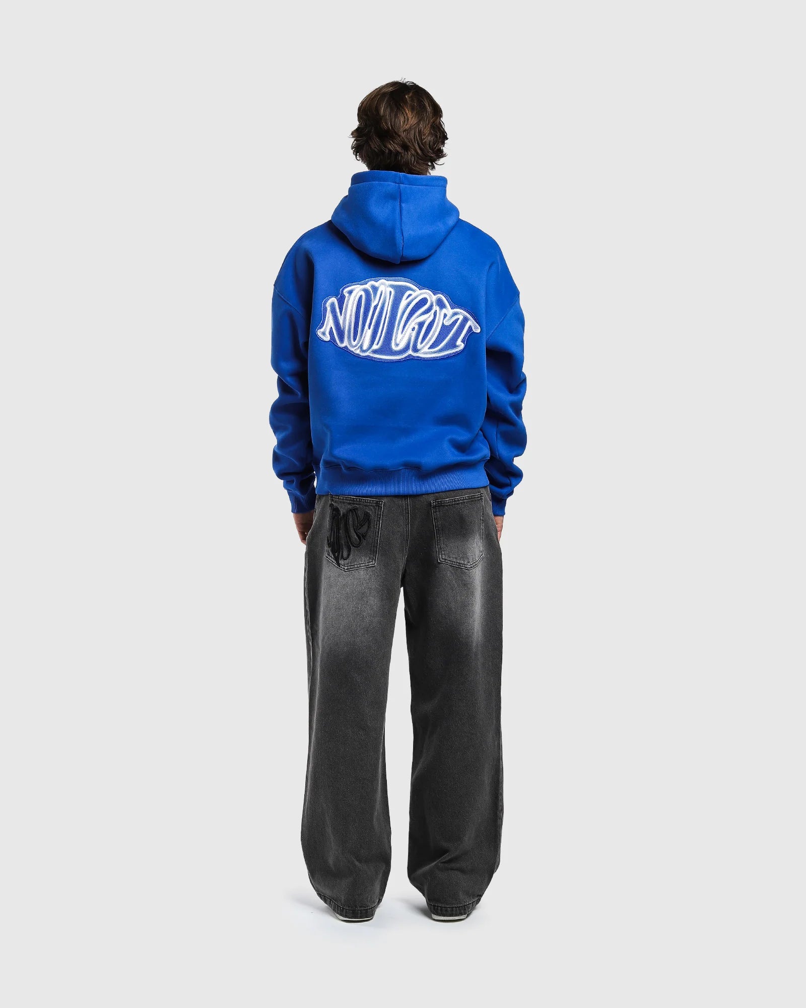 Dos hoodie oversize Noclout bleu royal porté homme logo blanc streetwear